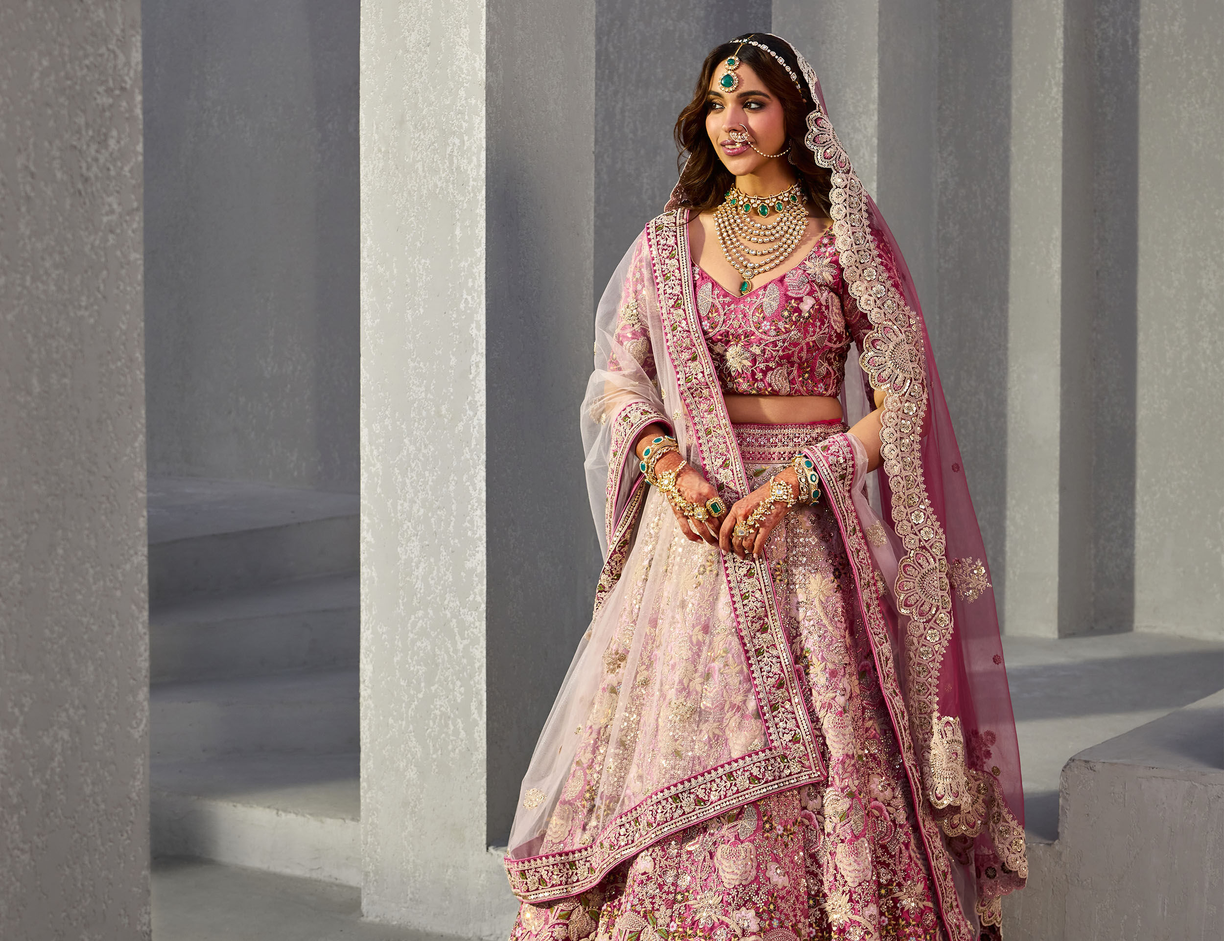 A bride showcasing a stunning pink velvet lehenga, blending luxury with timeless elegance.